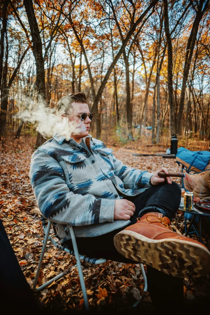 man enjoying a cigar buzz at camp site.