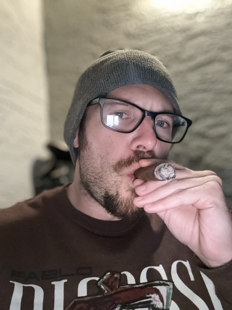 Picture of author smoking a cigar and looking into camera